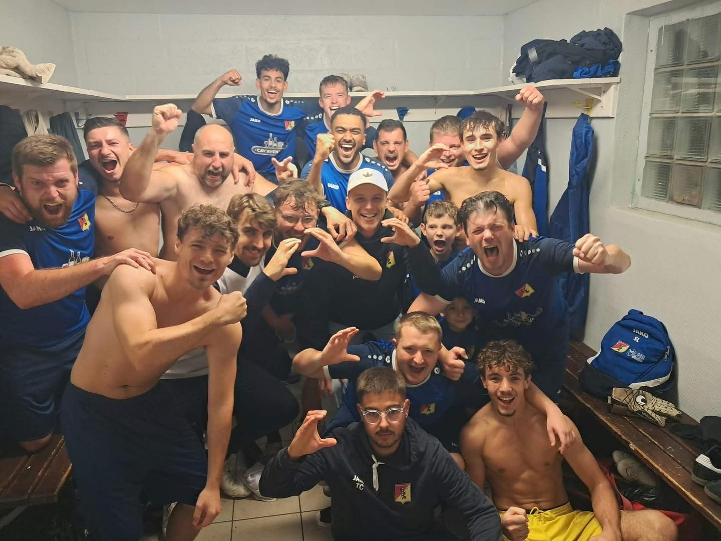 Les seniors du SCUDD, en maillot bleu, fêtent une victoire dans le vestiaire, poings levés