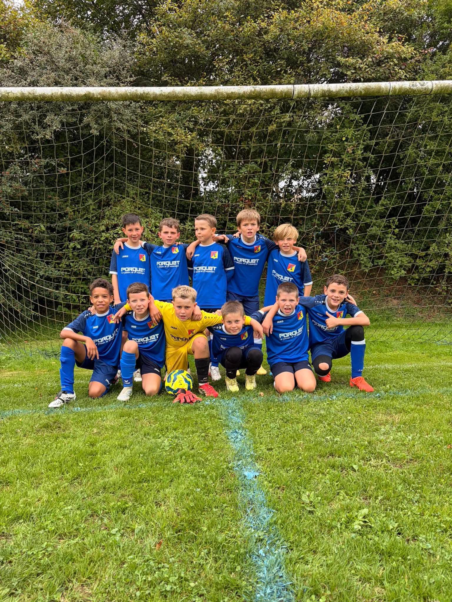 Les U11 du SCUDD posent devant le but, en maillot bleu, le gardien en jaune au centre