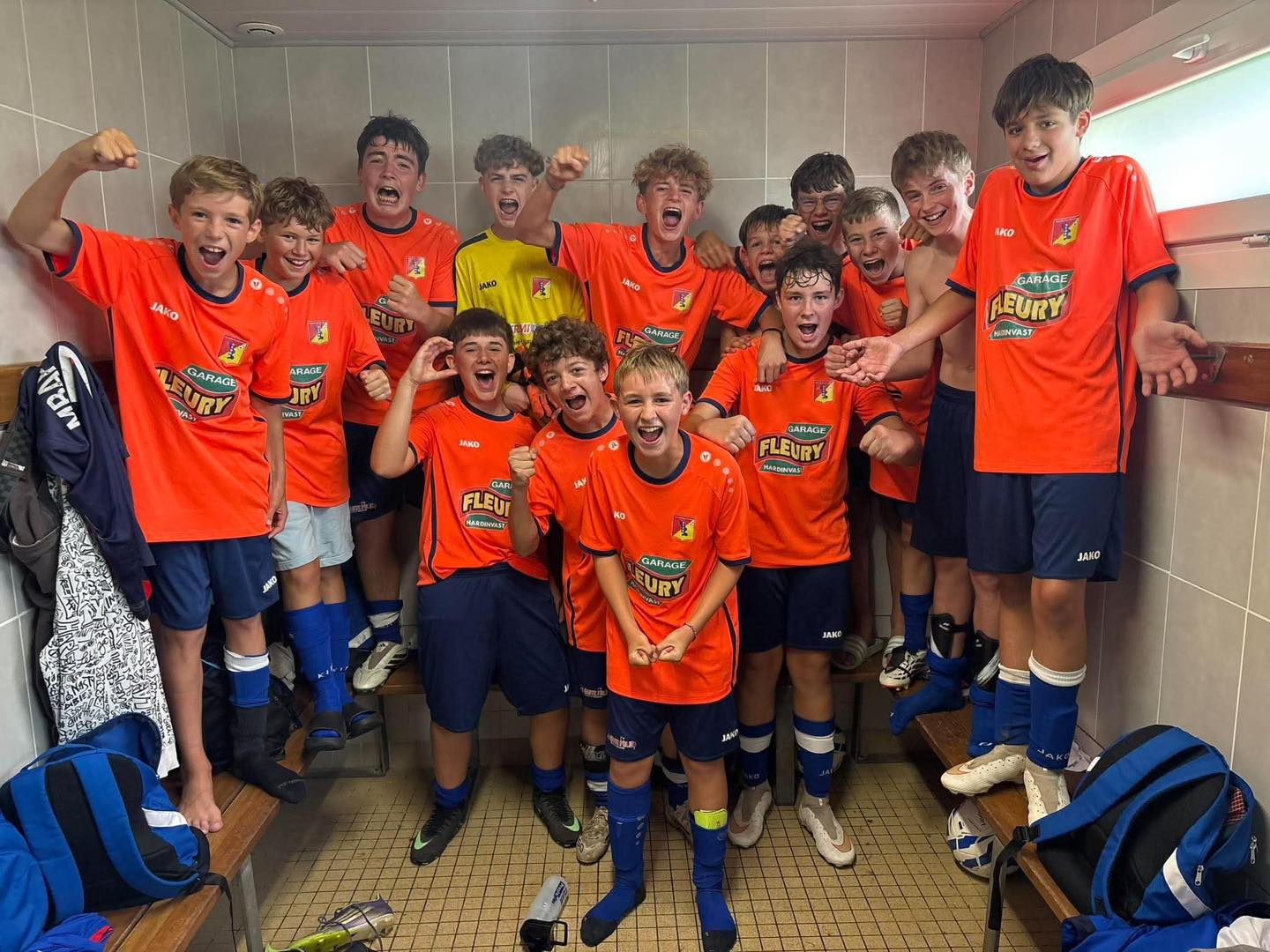 Les U15 du SCUDD, en maillot orange, fêtent leur victoire 14-0 contre le PLO dans le vestiaire
